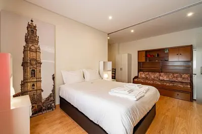 a bedroom with a bed with a picture of a tower at O'Porto Main Street St Catarina 2 Studio Apartment in Porto