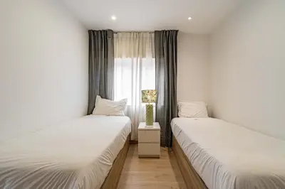 two twin beds in a room with a window at O'Porto Main street St Catarina 3 Rooftop in Porto