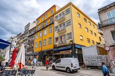 a white car parked in front of a yellow building at O'Porto Main street St Catarina 3 Rooftop in Porto