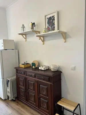 a kitchen with white cabinets and wooden floors and stools at O Alecrim in Porto