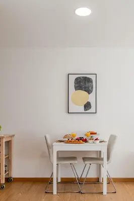 a white table with chairs and a table with food on it at Host Wise Stylish Studio with Garage in Porto
