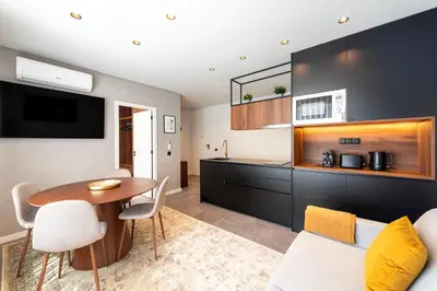 a living room with a table and a kitchen at DoisPontoZero Fonseca Cardoso in Porto