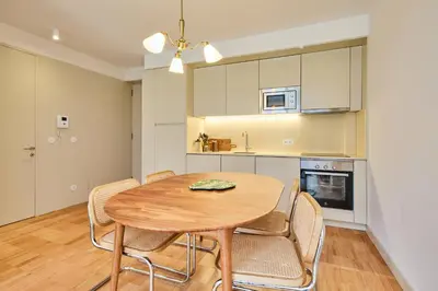 a kitchen and dining room with a wooden table and chairs at VIVA Ildefonso Serviced Apartments in Porto
