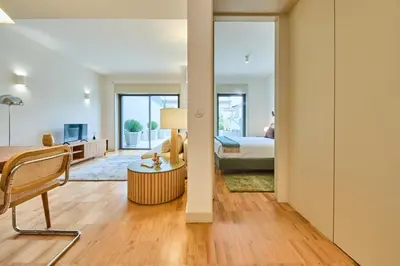 a bedroom with a bed and a living room at VIVA Ildefonso Serviced Apartments in Porto