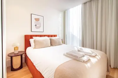 a bedroom with a large bed with white sheets at Miguel Bombarda House in Porto