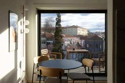 a room with a table and chairs on a balcony at Oporto City View - Ferreira Cardoso in Porto