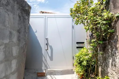 a white pivot door in a building with a hedge at Studio at Campanha Station in Porto