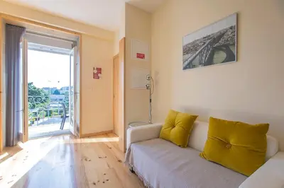 a living room with a couch and a large window at Cedofeita Back Garden in Porto