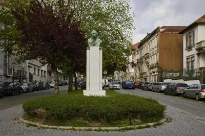 a statue of a man on a pedestal on a street at FLH Porto Central Apartments in Porto