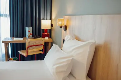 a desk in a room with a lamp and a phone at ABC Hotel Porto - Campanhã in Porto