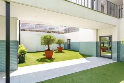 an internal courtyard of a building with two potted trees at VIVA River Apartment Gaia in Vila Nova de Gaia
