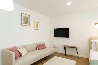 a white living room with a couch and a tv at VIVA River Apartment Gaia in Vila Nova de Gaia