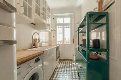 a kitchen with a washing machine and a washer at Downtown Retro Bolhao by Vacationy in Porto