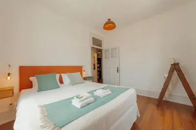 a bedroom with a large white bed with towels on it at Downtown Retro Bolhao by Vacationy in Porto
