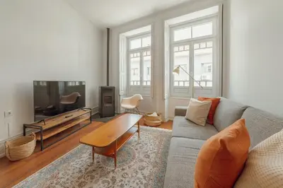 a living room with a couch and a tv at Downtown Retro Bolhao by Vacationy in Porto