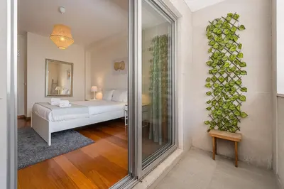 a bedroom with a bed and a plant on the wall at GuestReady - Cityscape residence with balcony in Porto
