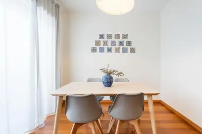 a dining room table with chairs and a vase on it at GuestReady - Cityscape residence with balcony in Porto