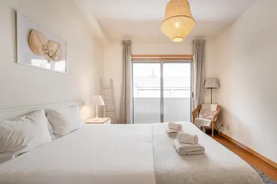 a bedroom with a large white bed with towels on it at GuestReady - Cityscape residence with balcony in Porto