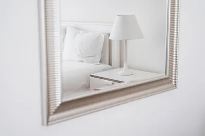 a mirror with a bed and a lamp on a table at GuestReady - Cityscape residence with balcony in Porto
