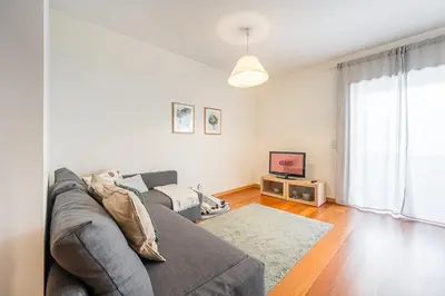 a living room with a couch and a tv at GuestReady - Cityscape residence with balcony in Porto