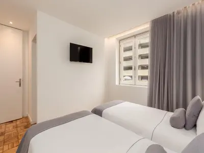 two beds in a white room with a window at Feel Porto Bacchus Townhouse in Porto