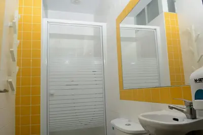 a bathroom with a toilet and a sink and a mirror at O2 Hostel in Porto