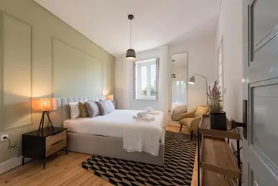 a bedroom with a large white bed and a couch at Douro Central in Porto
