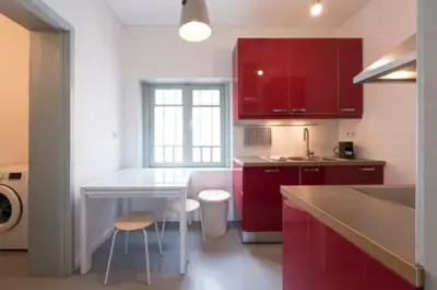 a kitchen with red cabinets and a white counter top at Douro Central in Porto