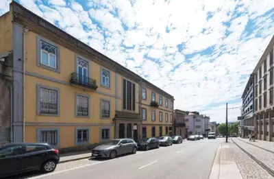 a street with cars parked next to a yellow building at Douro Central in Porto