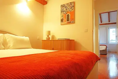 a bedroom with a bed with an orange blanket at PORTO SWEETHEART - Ricardo Jorge in Porto
