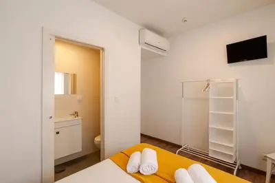 a small bedroom with a bed and a bathroom at Petit Suites by PCALE in Porto