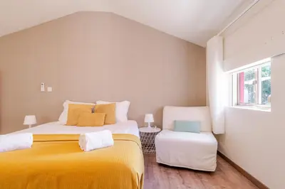 a bedroom with two beds and a window at Petit Suites by PCALE in Porto