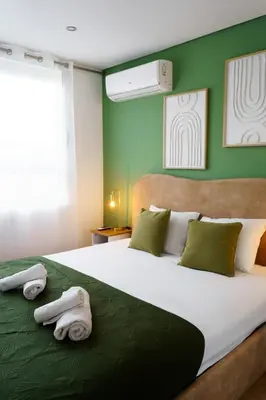 a bedroom with a large bed with green walls at Green Universe Porto by MyMoradia in Porto