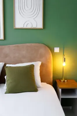 a bedroom with a bed with a green wall at Green Universe Porto by MyMoradia in Porto
