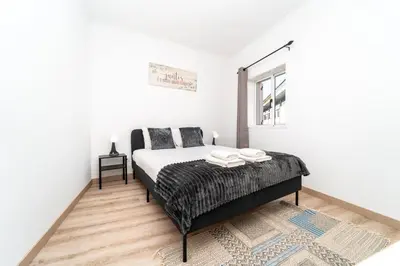 a white bedroom with a bed and a window at Gaia Family Nest in Vila Nova de Gaia