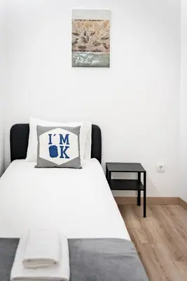 a bedroom with a white bed with a pillow on it at Gaia Family Nest in Vila Nova de Gaia