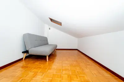 a chair in an empty room with a wooden floor at Gaia Family Nest in Vila Nova de Gaia