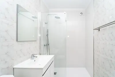 a white bathroom with a sink and a shower at Gaia Family Nest in Vila Nova de Gaia