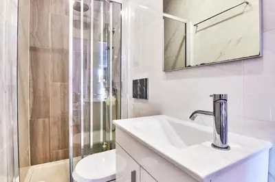 a white bathroom with a sink and a shower at Campanhã Clock House with terrace in Porto