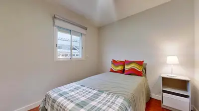 a bedroom with a bed with colorful pillows and a window at Porto Sweet Home in Porto