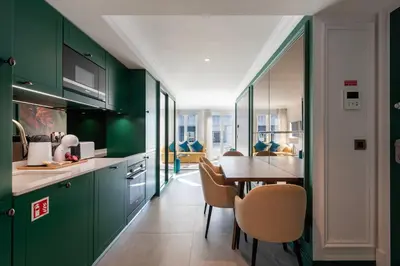 a kitchen with green cabinets and a table with chairs at Charming apartment in Cedofeita by Lisbeyond in Porto