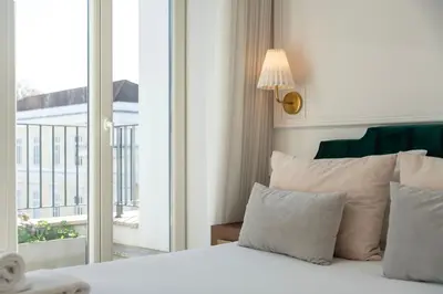 a bedroom with a white bed with a window at Charming apartment in Cedofeita by Lisbeyond in Porto