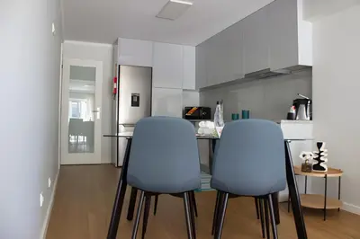 a kitchen with two blue chairs and a table at Douro Sunset Terrace in Vila Nova de Gaia