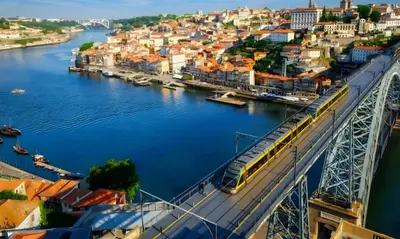 a train crossing a bridge over a river at Douro Sunset Terrace in Vila Nova de Gaia