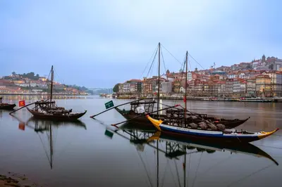 two boats are docked in the water in a city at Douro Sunset Terrace in Vila Nova de Gaia