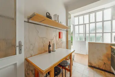 a kitchen with a white counter and a table at Cedofeita Terrace by Hosty in Porto