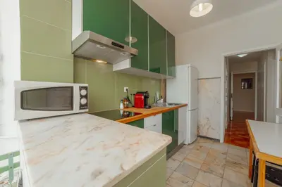 a kitchen with green cabinets and a microwave at Cedofeita Terrace by Hosty in Porto