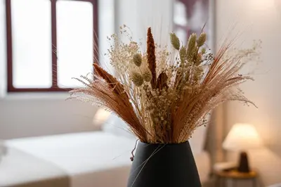a black vase filled with dried flowers on a table at GuestReady - Joy Apartments in Porto
