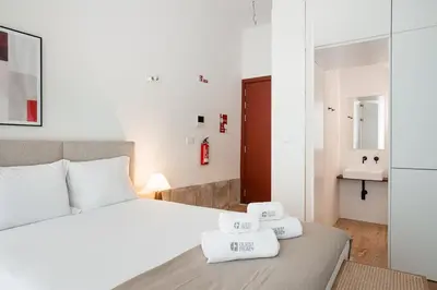 a bedroom with a bed with two towels on it at GuestReady - Joy Apartments in Porto