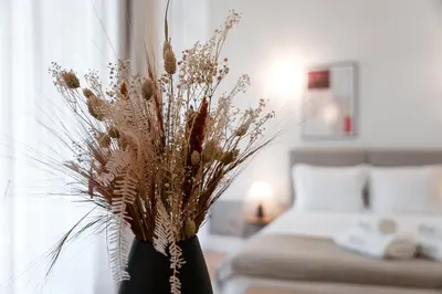 a black vase filled with dried flowers in a room at GuestReady - Joy Apartments in Porto